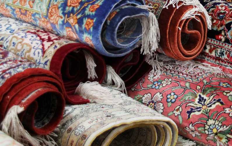 Stack of rolled hand woven rugs