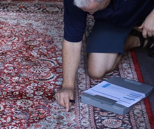 Kurt Gilbertson pre-inspecting a rug