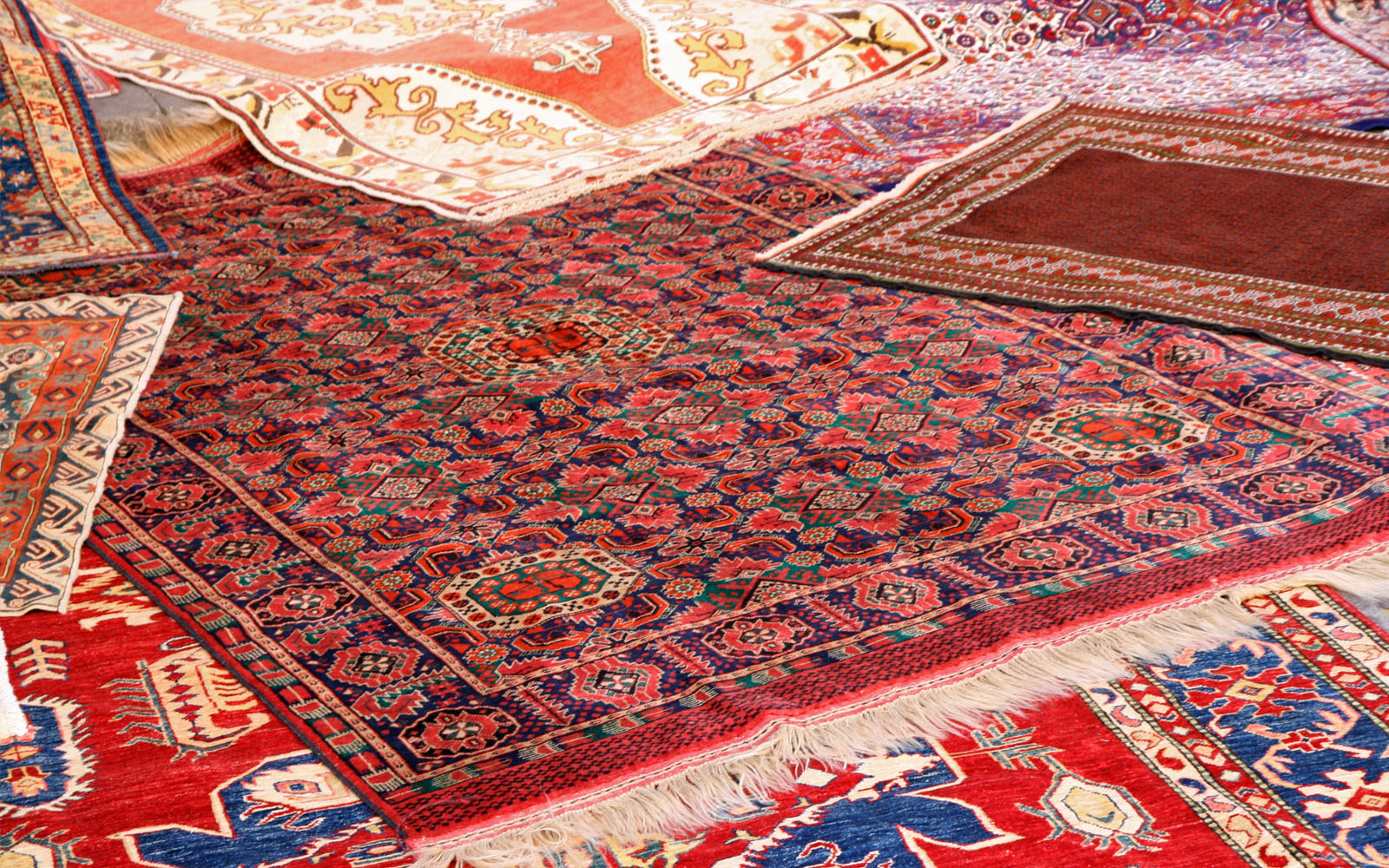 Various rugs laid out on the floor overlapping